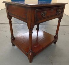 an old wooden table with two drawers on it