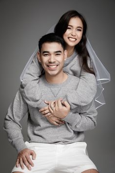 a young man and woman are posing for a wedding photo with their arms around each other