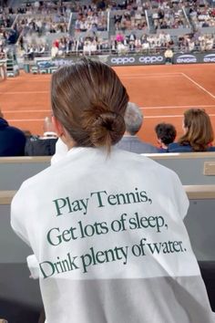 a woman with a towel on her back at a tennis match