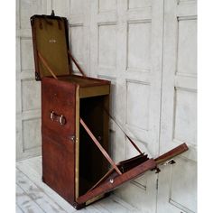 an open suitcase sitting on the floor in front of a white wall with wooden slats