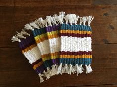 three multicolored blankets laying on top of a wooden floor