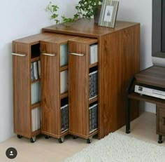 a wooden bookcase with several books on it and a potted plant sitting on top