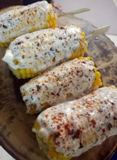 three corn on the cob with cheese and seasoning sprinkled on them