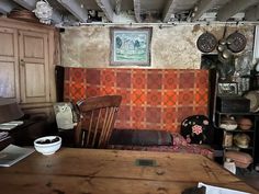 an old fashioned kitchen with wooden table and chairs