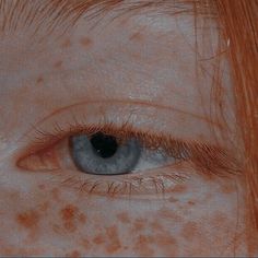 an orange haired woman with freckles on her face