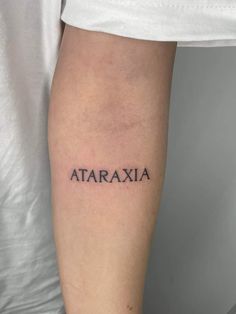 a woman's arm with the word ataraxia tattooed in black ink