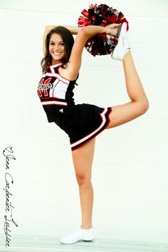 a cheerleader posing with her pom poms