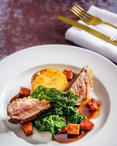 a white plate topped with meat and vegetables