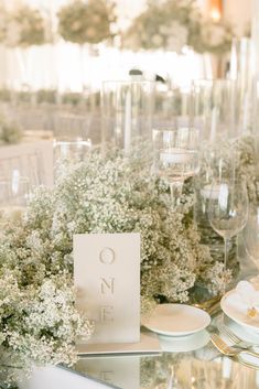 the table is set with white plates and place settings for an elegant dinner or party