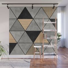 an abstract wall mural in grey, beige and black with geometric shapes on the walls