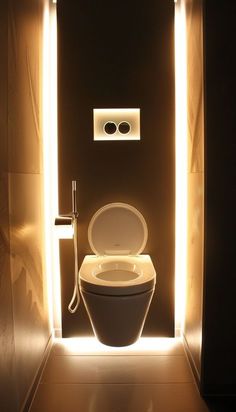 an illuminated toilet in a dimly lit bathroom