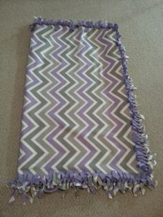 a purple and gray blanket laying on the floor