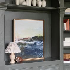 a painting and lamp on a shelf in a room