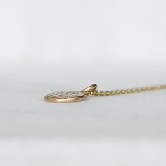 Sweet diamond and gold wildflower necklace. I melted and hammered 2 grams of 14k yellow Gold into an organically shaped disc. I set sparkly white diamonds into the center of wildflowers hand drawn with chasing tools. Hangs from a delicate 1.3mm cable chain with a spring clasp. Pebble - about 10mm x 11mm's, and roughly 2mm's thick Diamonds - 1.7mm Si1 White Diamonds - Conflict-Free Because each pendant is made by hand, no two will be exactly the same. That being said, I am a perfectionist when it Delicate Engraved Charm Necklace, Delicate Yellow Gold Birth Flower Jewelry, Delicate Yellow Gold Charm Necklace With Birth Flower, Delicate Yellow Gold Birth Flower Charm Necklaces, Delicate Yellow Gold Birth Flower Charm Necklace, Minimalist Yellow Gold Necklace With Flower Charm, Nature-inspired Gold Flower Pendant Jewelry, Hammered Yellow Gold Nature-inspired Jewelry, Delicate 14k Gold Engraved Charm Necklace