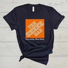 'The Cheer Dad-Less saving. More doing.' Tee! This shirt is a unisex fit. ---T-SHIRT FABRIC DETAILS--- 100% airlume combed and ringspun cotton Heather colors are 4.2 oz., 52% airlume combed and ringspun cotton, 48% polyester, 32 singles Heather Athletic is 90% airlume combed and ring-spun cotton, 10% polyester ---CARE INSTRUCTIONS--- Wash item inside out in cold water with like colors. Do not bleach. Do not dry clean. Do not iron directly over the design. ---DISCLAIMER--- Actual product colors m Cheer Tees Shirt Ideas, Cheer Dad Shirt Ideas, Cheer Dad Shirt, Cheer Dad Shirts, Allstar Cheer, Cheer Team Gifts, Sports Parent, Dad Shirts, Daughters Shirt