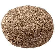 a brown round ottoman sitting on top of a white floor