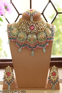 the necklace and earrings are on display in front of a window