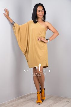 "Short yellow dress for women. Off shoulder elegant short dress in mustard yellow. One shoulder cocktail party dress. A knee length evening dress. PRODUCT SIZE : One Size * Chest : min 32\" up to 44\" * Waist : up to 44\" * Hips : up to 44\" * Length : 35\" from shoulder to hem Please note that all measurements have been taking when the dresses were laying flat. This means that the dress will hang a bit lower once you actually wear them, because of the weight of the fabric. MATERIAL : * ITY Poly Yellow One-shoulder Mini Dress, Chic Gold One-shoulder Mini Dress, Gold One-shoulder Mini Dress, Yellow One-shoulder Midi Dress For Evening, Yellow One-shoulder Evening Midi Dress, Summer Off Shoulder Dress With Asymmetrical Neckline, Summer Off-shoulder Dress With Asymmetrical Neckline, Yellow One Shoulder Midi Dress For Party, Yellow One-shoulder Midi Dress For Party