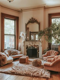 a living room filled with furniture and a fire place in front of two large windows