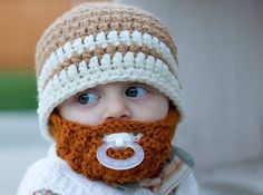 a baby wearing a crocheted hat with a pacifier in it's mouth