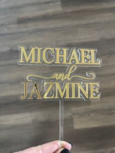 a hand holding up a sign that says michael and jazmine