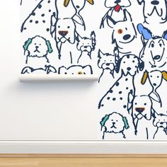 a drawing of dogs on a wall next to a roll of toilet paper and a pen