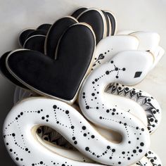 decorated cookies in the shape of hearts and snakes on a platter for valentine's day