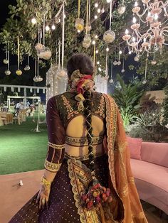 a woman standing in front of a couch wearing an elaborate dress and headpieces