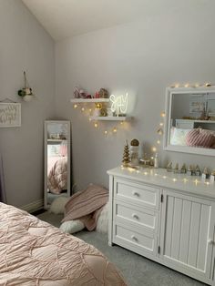 a bedroom with white furniture and lights on the wall