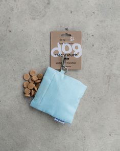 a small blue pouch with dog treats in it next to a tag that says go through