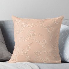 a pink pillow on a gray couch