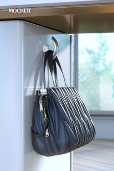 a black purse hanging on the side of a white wall