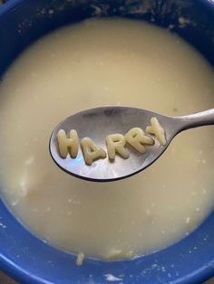 a spoon with the word harres written on it is in a blue bowl