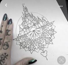 a woman's hand with tattoos on it and a drawing of a castle in the background