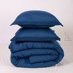 three blue pillows stacked on top of each other