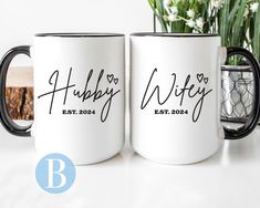 two personalized coffee mugs sitting next to each other on a table with flowers in the background