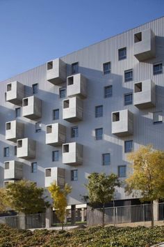 an apartment building with many windows and balconies on the side of it's face