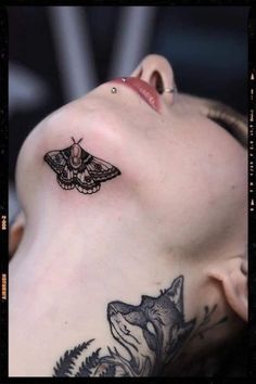 a woman with a moth tattoo on her shoulder and behind her head is a wolf