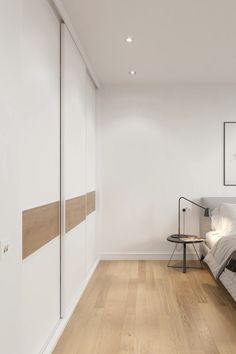 a bedroom with white walls and wooden floors