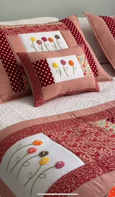 a bed with red and white bedspread, pillows and polka dot pillow cases