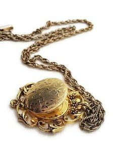 Ornate photo locket pendant with ornate floral details. The frame surrounds the locket. The chain has a hinged fold over clasp in perfect working order. The locket also snaps tightly shut. The only notable wear would be fading on the gold plated chain so the chain looks like a combination of silver and gold. There is also one small wear mark in the gold on the Locket itself. I included close up pictures. This is a true vintage locket not vintage style. Antique locket will ship in a gift box. Ple Art Deco Locket, Large Locket, Victorian Locket, Cameo Pendant Necklace, Vintage Locket, Picture Locket, Antique Locket, Vintage Lockets, Romantic Jewellery