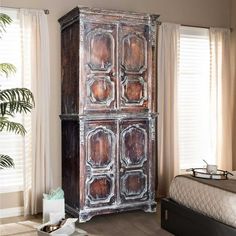 an old wooden cabinet in a bedroom next to a bed