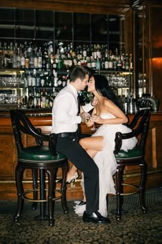 a man and woman sitting at a bar