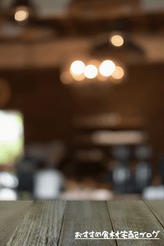 an empty wooden table top with blurry lights in the background