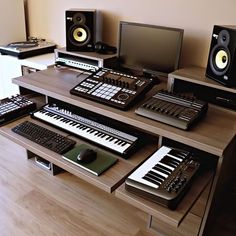 there are many electronic equipment on the desk together, including keyboards and music mixers