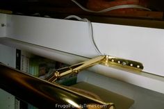 a close up of a gold handle on a white cabinet with a book shelf in the background