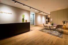 an office with wooden floors and chairs in the center, along with a reception desk