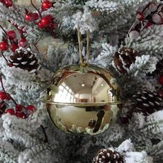 an ornament hanging from the side of a christmas tree with pine cones and red berries