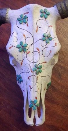 a cow skull with flowers painted on it