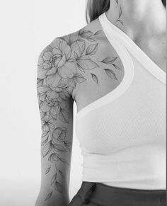 a woman with a flower tattoo on her arm and shoulder, in black and white